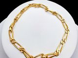 a close up of a gold chain bracelet on a white plate