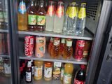 a refrigerator filled with drinks and sodas in a kitchen