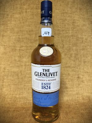 une bouteille de whisky The Glenlivett posée sur une table