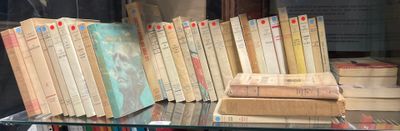 de nombreux livres posés sur une table en verre près de la fenêtre