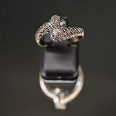 une image d'une bague en diamant sur une surface noire