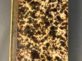 an old book with black spots on it sitting on top of a table