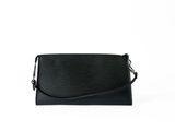 the black leather clutch bag is on a white background