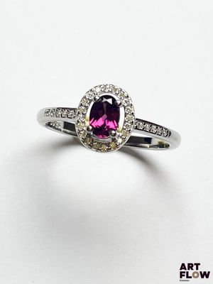 gros plan d'une bague en diamant rose et blanc sur une surface blanche