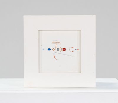 un cadre blanc orné d'un dessin, posé sur une étagère