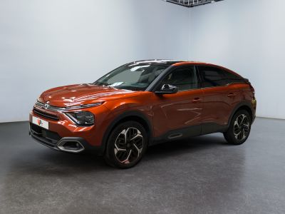 un SUV rouge garé dans une pièce aux murs blancs