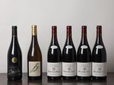 des bouteilles de vin alignées sur une table en bois devant un mur blanc