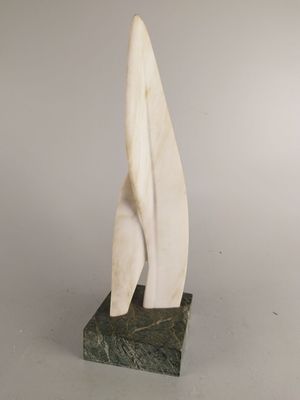 sculpture en marbre représentant un voilier, posée sur un socle en marbre, sur fond gris