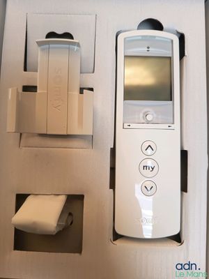 une télécommande dans une boîte, avec un rouleau de papier toilette à côté
