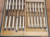 beaucoup de stylos dans une boîte posée par terre