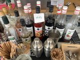 de nombreuses bouteilles et cuillères posées sur une table où se trouvent de nombreux ustensiles