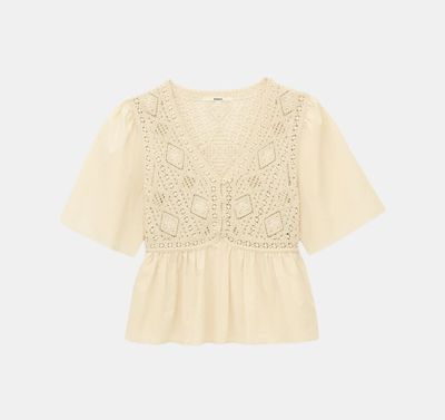 a white blouse with a crochet pattern on the shoulders