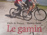 une affiche représentant un couple faisant du vélo sur la plage