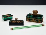 trois morceaux de verre vert ornés de motifs dorés et un stylo vert