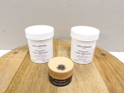 deux pots de crème posés sur une table en bois, à côté d'un pot de crème