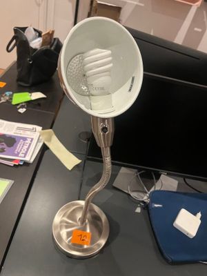 a desk with a lamp on it and a laptop on the desk