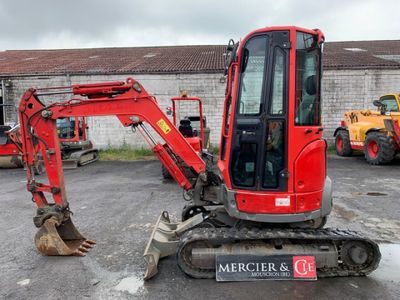 a red excavator that is parked in a parking lot