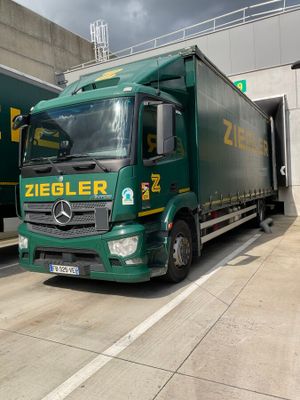 a green truck that is parked in front of a building