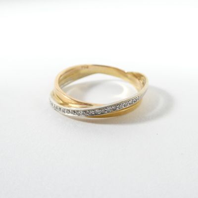 gros plan d'une bague en or et diamants sur une surface blanche
