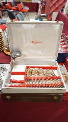 a box of silverware on a table with a red table cloth