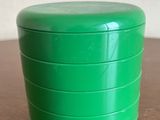 un récipient vert posé sur une table en bois