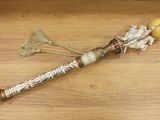 un petit bâtonnet en bois surmonté d'une perle en or