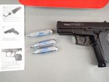 a gun that is sitting on a table next to some batteries
