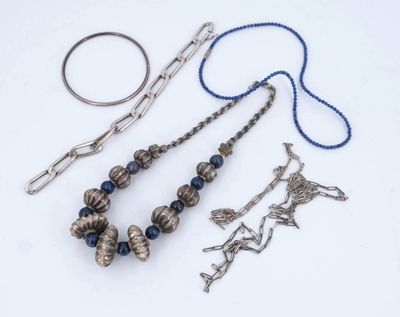 a necklace, bracelet, ring, and other jewelry on a white surface
