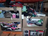 two boxes with clothes on them sitting on a pallet in a warehouse