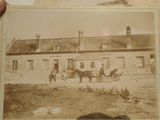 an old photo of a horse and buggy in front of a house