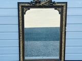 a mirror sitting on the floor in front of a blue wall