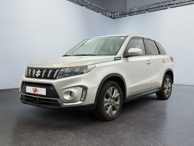 La Suzuki Vitax blanche est garée dans une grande pièce.