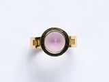une image d'une bague en or avec une pierre rose au centre