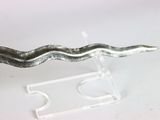 a small metal snake on a stand on a white surface