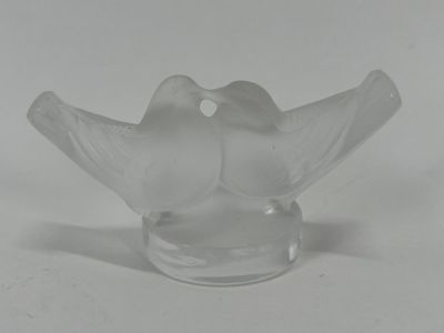 a glass bird that is sitting on top of a glass bowl