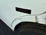 a close up of a white car with a sticker on it