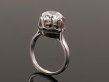 a close up of a diamond ring on a reflective surface