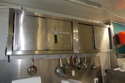 de nombreuses casseroles et poêles accrochées au mur de la cuisine