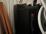 a black box sitting on top of a white shelf next to a stack of chairs