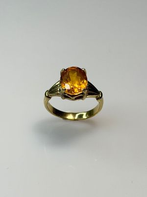 a close up of a gold ring with a citrine stone