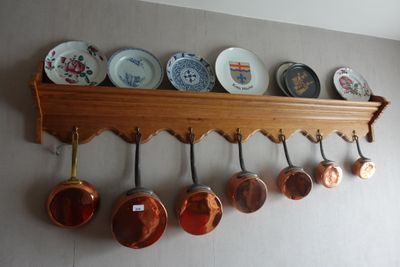 de nombreuses casseroles et poêles accrochées au mur