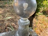 une boule de verre posée au sommet d'un poteau en pierre