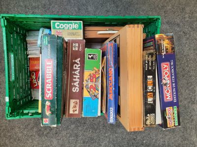 many books in a green box on the floor