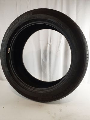 a close up of a tire on a white surface with a curtain in the background