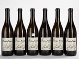 six bouteilles de vin sont alignées sur une surface blanche
