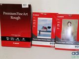 deux boîtes de papier photo « Premium Fine Art » de Canon posées sur une table
