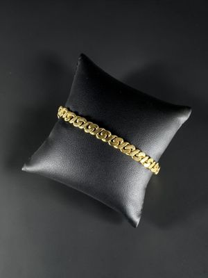 un bracelet en or posé sur un coussin noir