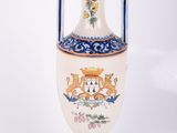 un vase blanc orné d'un motif bleu et jaune
