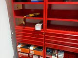 deux étagères rouges sur lesquelles sont posés des outils, dans une pièce