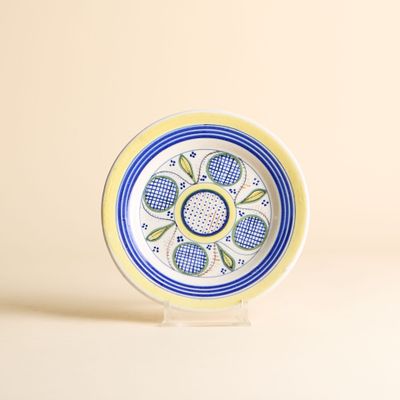 une petite assiette ornée d'un motif bleu et jaune